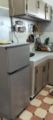 a kitchen with a refrigerator and a tile floor at Dar Chez Ali in Mhamid