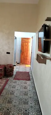 a hallway with a wooden door and a television at Dar Chez Ali in Mhamid