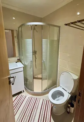 a bathroom with a shower and a toilet and a sink at Le cocon d'Asilah Mer et Confort in Oulad Akkou
