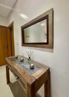 a mirror on a wall with a wooden table at Le cocon d'Asilah Mer et Confort in Oulad Akkou