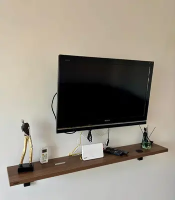 a flat screen tv sitting on a wooden shelf at Le cocon d'Asilah Mer et Confort in Oulad Akkou