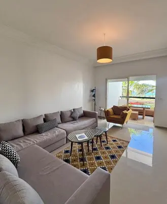 a living room with a couch and a table at Le cocon d'Asilah Mer et Confort in Oulad Akkou