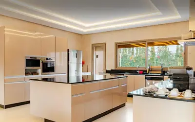a large kitchen with white cabinets and black counter tops at Villa privée sans vis-à-vis,Padel,Tennis, Five in Oulad Mazoug