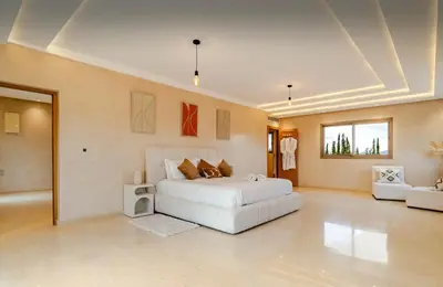 a large bedroom with a white bed and a couch at Villa privée sans vis-à-vis,Padel,Tennis, Five in Oulad Mazoug