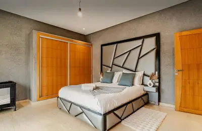 a bedroom with a large bed and a fireplace at Villa privée sans vis-à-vis,Padel,Tennis, Five in Oulad Mazoug
