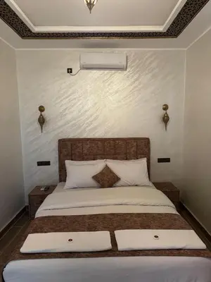 a bedroom with a large bed with two pillows at Merzouga morocco in Merzouga