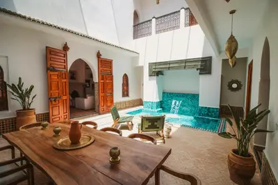 a living room with a table and a swimming pool at Villa Riad Soles Heated pool Luxury and Beauty in Douar Soukkane
