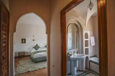 a bedroom with a bed and a sink and a mirror at Villa Riad Soles Heated pool Luxury and Beauty in Douar Soukkane