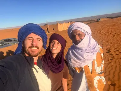 a group of three people standing in the desert at Bivouac Desert Du Maroc in Mhamid
