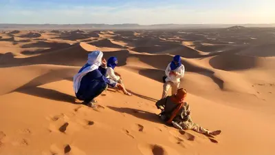 a group of people sitting in the desert at Bivouac Desert Du Maroc in Mhamid