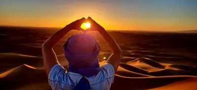 a man in the desert looking at the sunset at Bivouac Desert Du Maroc in Mhamid