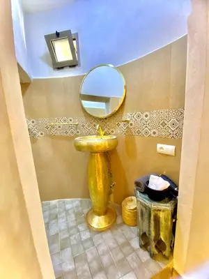 a bathroom with a gold sink and a mirror at Riad Oum h&N in Srarhna