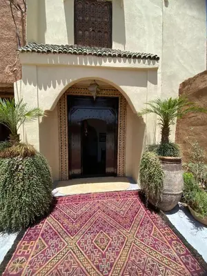 a building with a rug in front of a door at Riad Oum h&N in Srarhna