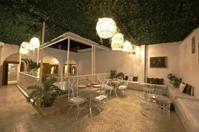a patio with a table and chairs in a building at Riad Oum h&N in Srarhna