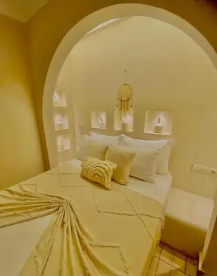 a bedroom with a large bed with an arched ceiling at Riad Oum h&N in Srarhna