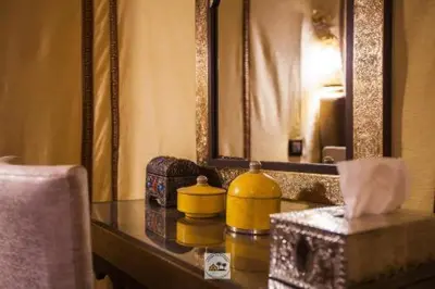 a bathroom counter with a mirror and a yellow container on it at kasbah estrella in Merzouga