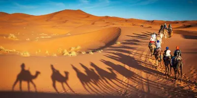 a group of people riding horses in the desert at kasbah estrella in Merzouga