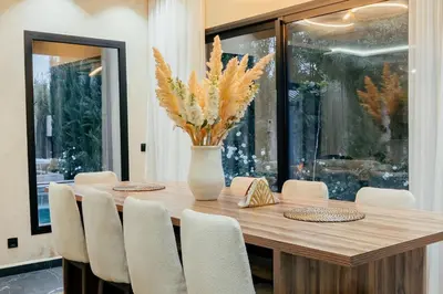 a dining room table with chairs and a vase with flowers at Stunning luxury Villa with Mountain Views in Sbiti