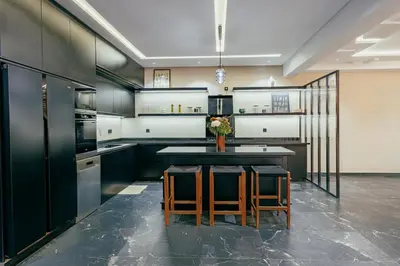 a kitchen with black cabinets and a table with chairs at Stunning luxury Villa with Mountain Views in Sbiti