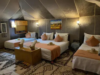 a bedroom with two beds in a tent at Magamane luxury camp in Merzouga