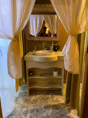 a bathroom with a sink and a man in the mirror at Magamane luxury camp in Merzouga