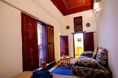 a living room with a chair and a door at Dar bab jdid Rcif- step away from historic sites in Fès