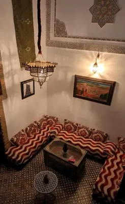 a living room with a couch and a table at Dar bab jdid Rcif- step away from historic sites in Fès