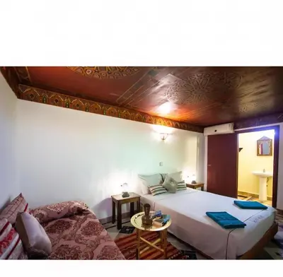 a bedroom with a large bed and a table at Dar bab jdid Rcif- step away from historic sites in Fès