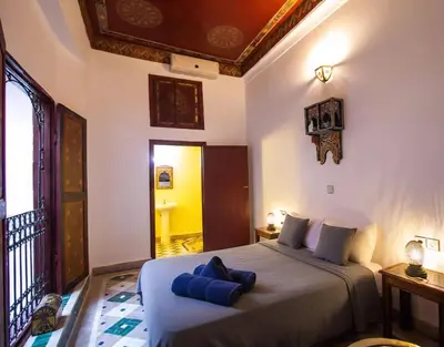 a bedroom with a bed with blue pillows on it at Dar bab jdid Rcif- step away from historic sites in Fès