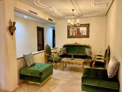 a living room with green furniture and a chandelier at Prestigia Luxury Apartments Fes in Fès