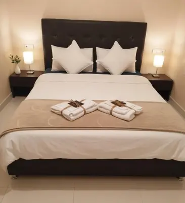 a bedroom with a large bed with two towels at Prestigia Luxury Apartments Fes in Fès