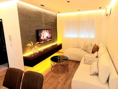 a living room with a white couch and a tv at Suite Bahiya unica in Fès