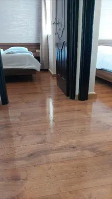 a room with a wooden floor with a bed and a door at Suite Bahiya unica in Fès