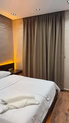 a bedroom with a white bed and a curtain at Suite Bahiya unica in Fès