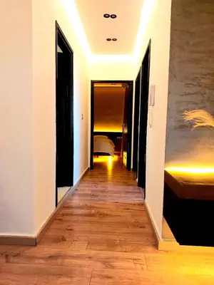 a hallway with white walls and a wooden floor at Suite Bahiya unica in Fès