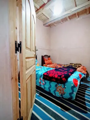a room with two beds in it with a door at Auberge le calme restaurante in Bou Tharar