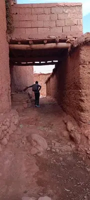 a person walking through a brick tunnel in an alley at Dar sonic in Ouarzazate