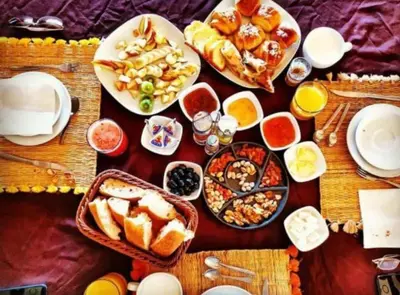 a table with many plates of food on it at Itran luxury camp in Merzouga