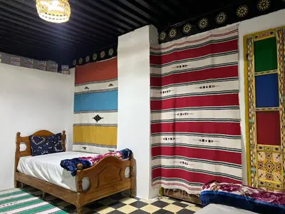 a bedroom with a bed and a wall with colorful stripes at chembre Naima mbarki in Fès