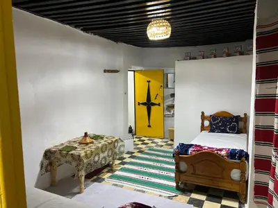 a bedroom with a bed and a yellow door at chembre Naima mbarki in Fès