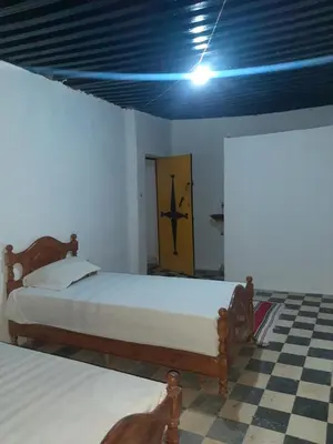 a bedroom with two beds and a yellow door at chembre Naima mbarki in Fès