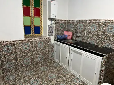 a bathroom with a sink and a patterned wall at chembre Naima mbarki in Fès