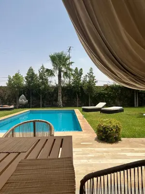 a swimming pool with a wooden bench next to at Villa à Marrakech-avec piscine privėe in Douar Soukkane