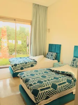two beds in a room with a window at Villa à Marrakech-avec piscine privėe in Douar Soukkane