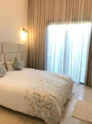 a bedroom with a bed and a large window at Villa à Marrakech-avec piscine privėe in Douar Soukkane