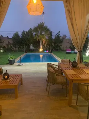 a patio with a table and a swimming pool at Villa à Marrakech-avec piscine privėe in Douar Soukkane