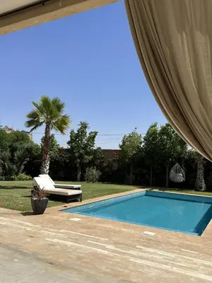 a swimming pool in a yard with a palm tree at Villa à Marrakech-avec piscine privėe in Douar Soukkane