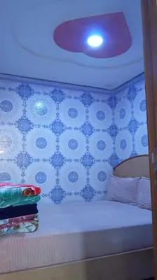 a bedroom with a bed with blue and white wallpaper at Dar Bouchikhi in Moulay Yacoub