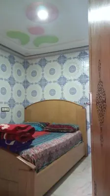 a bedroom with a bed with a blue and white wall at Dar Bouchikhi in Moulay Yacoub