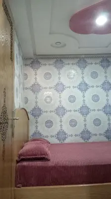 a bedroom with a bed with blue and white wallpaper at Dar Bouchikhi in Moulay Yacoub